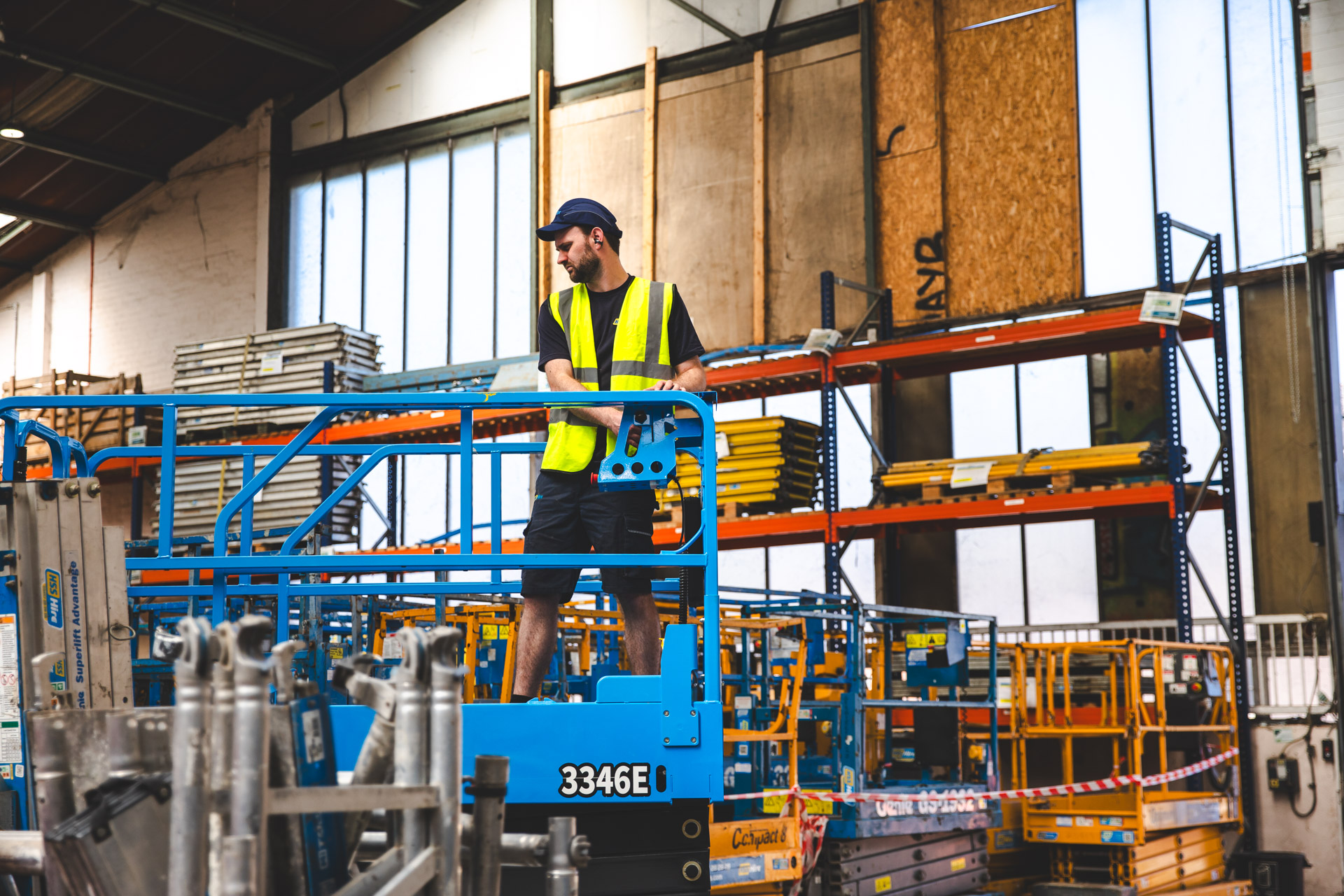 A man working in a hire equipment company, looking for the equipment requested by a company and using the invoice as reference.