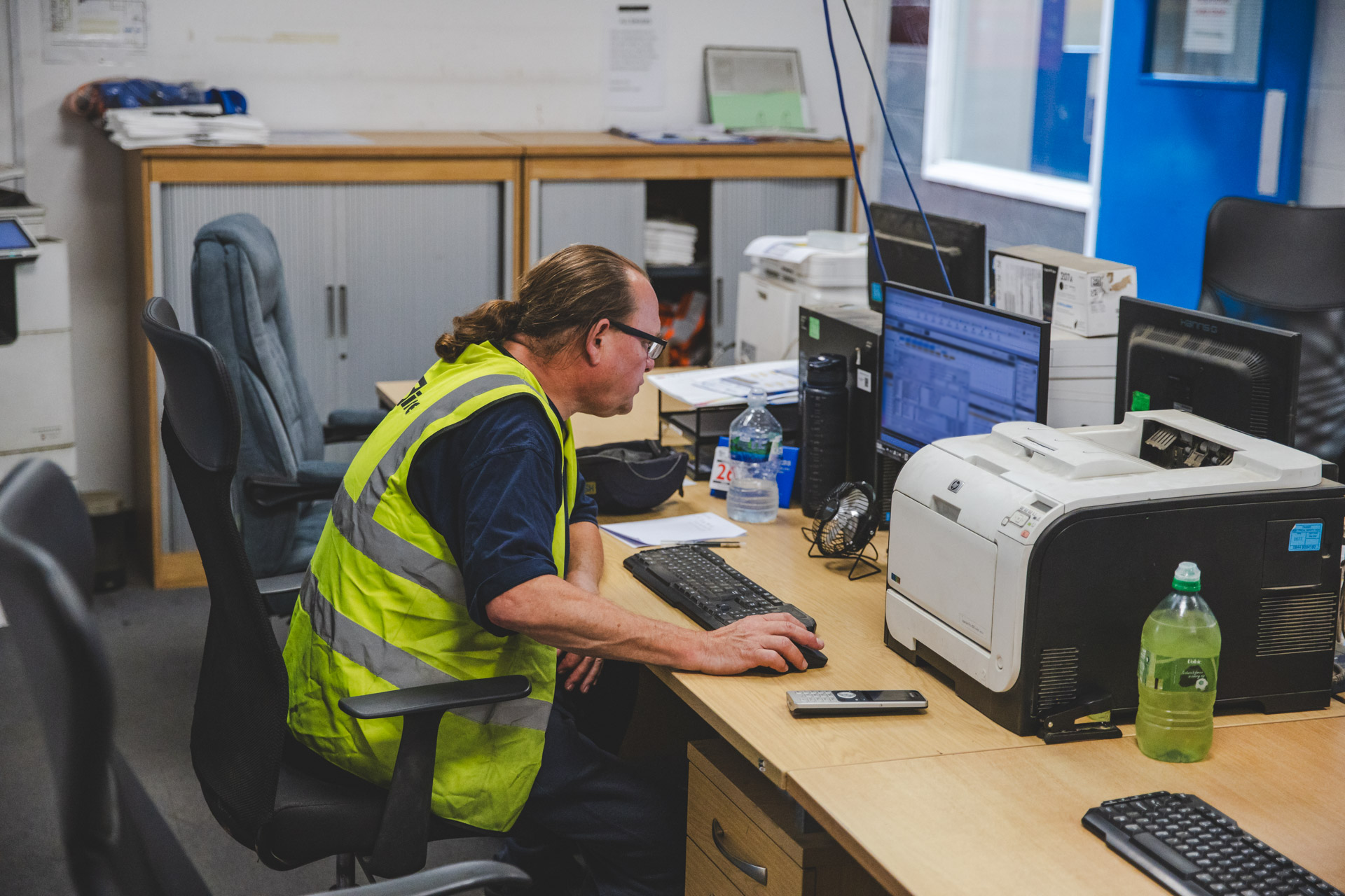 A man checking his computer to ensure that no one is past the equipment due date.
