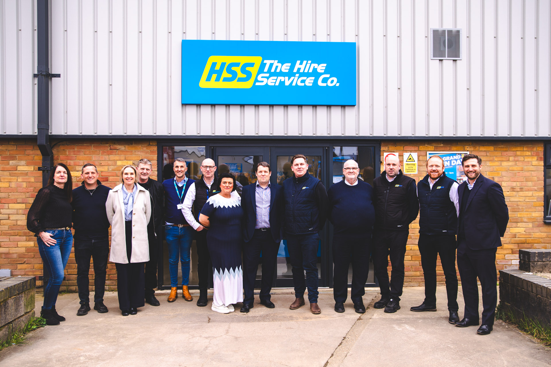 The Hire Service Company team, posing in front of the entrance of one the sites, to show that they are an inclusive team.